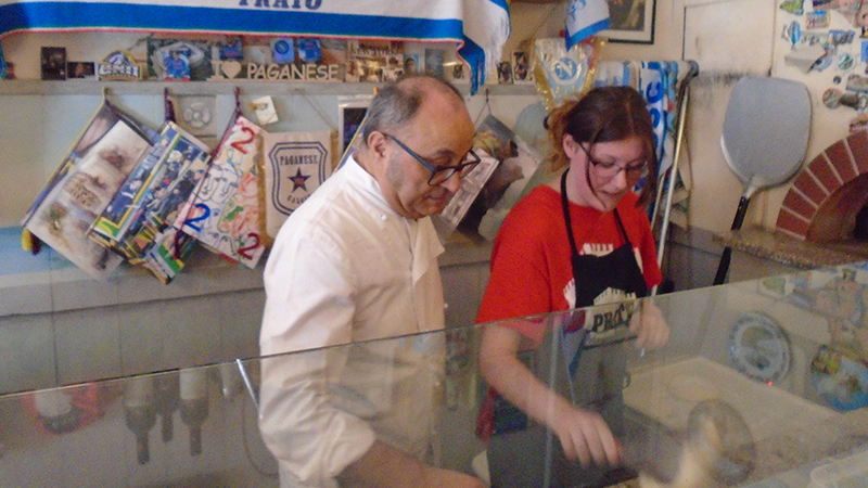 Gerardo Tortora guides Kelsey McDonnell ’25 as she makes her pizza.