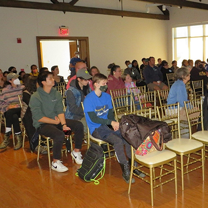 A crowd gathers at a presentation.