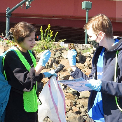 Two students discuss picking up garbage outside.