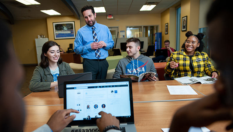 Matt Caporale (standing) leads a career development training session with students before the pandemic.