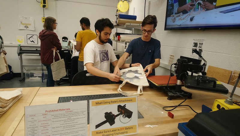 Image of Austin Thomas helping a student during a makerspace activity.