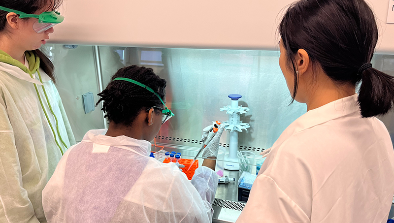 Dr. Huan Gu (right) instructs students in the lab.