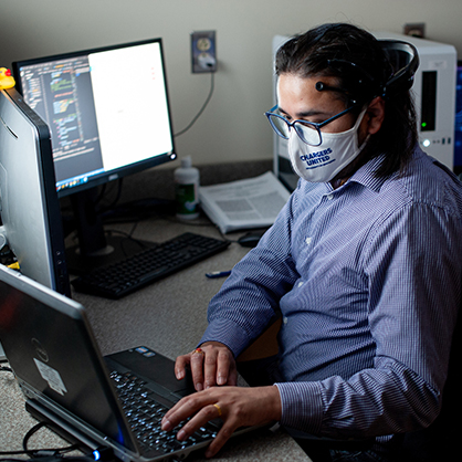 A student works on a computer at a desk.