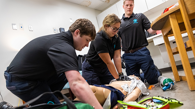 Medical professionals training with a mannequin.