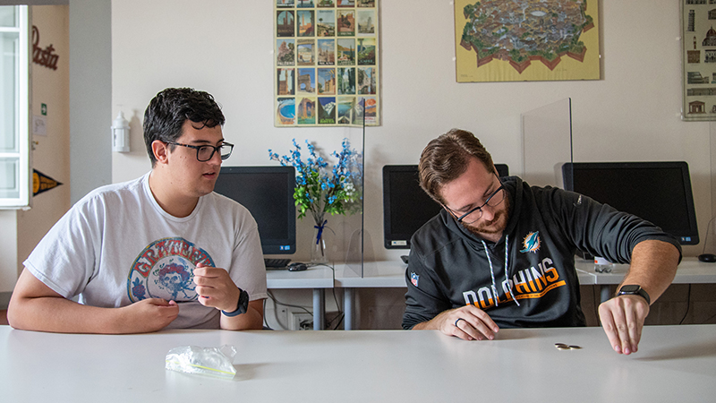 Tom Woods ’23 (left) and Liam Orsini ’24 practice magic tricks during class.