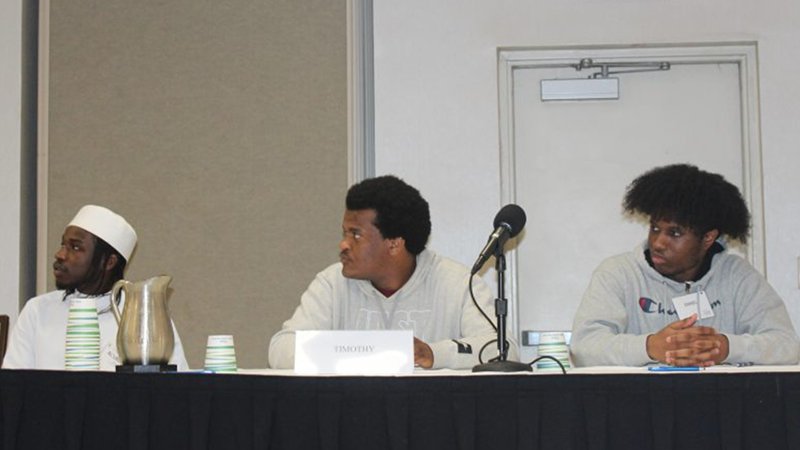 Three panel members sitting at a table. 