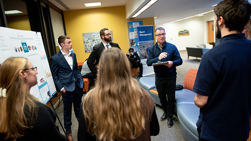 Prof. Michael Davis (right, center) checks out students’ posters at the event.