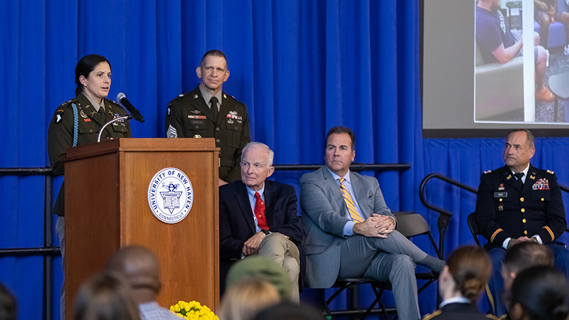 Army Major Kristen Griest speaks at a podium.