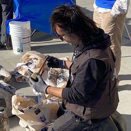 sTo Len examines trash collected at the event.