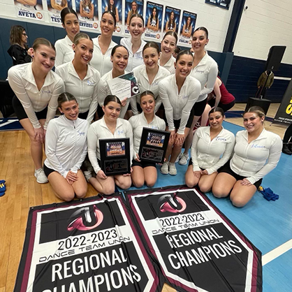 The Chargers pose with their regional championship banners.