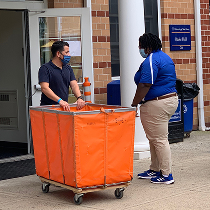 David Muñoz pushing a cart into Bixler Hall.