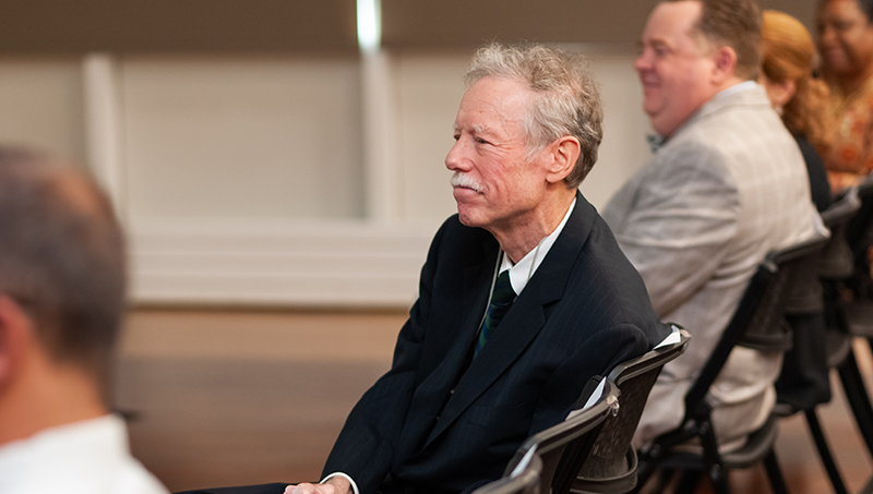 Philip H. Bartels ’11 Hon., listens to the students’ presentations.