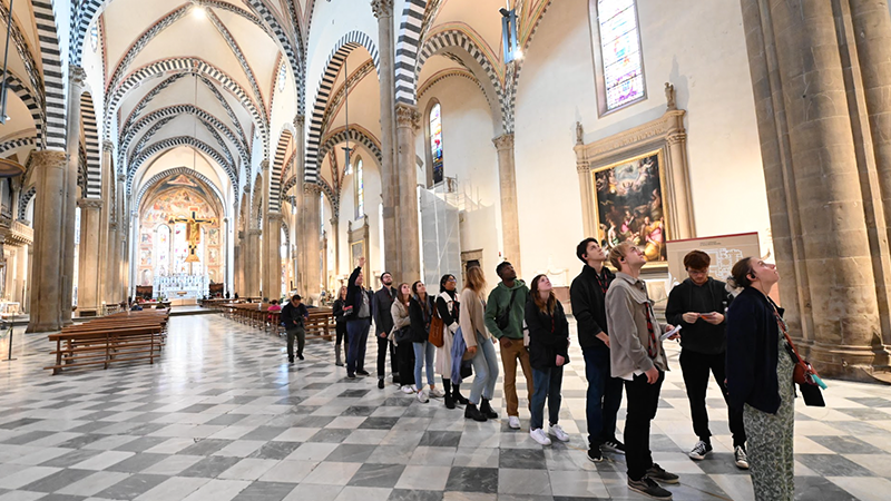 Students standing on a brass meridian line in the church.