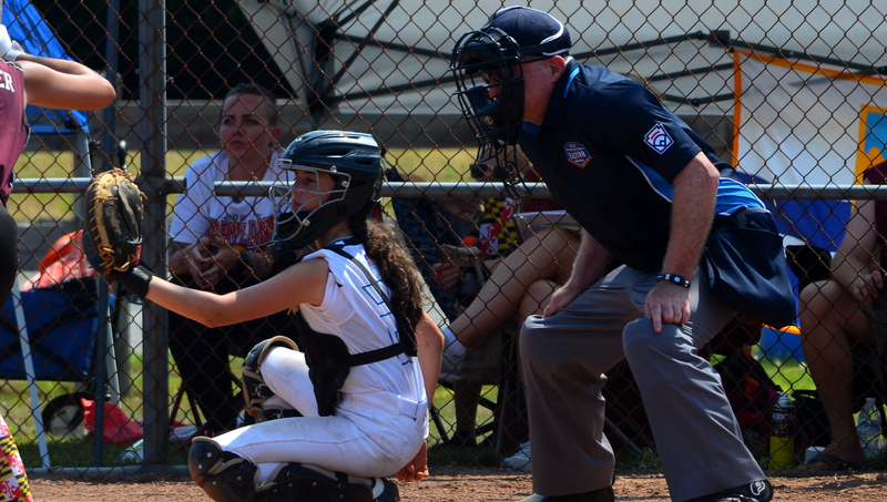 Brian Marks, J.D., Ph.D., (right) umpiring during the Little League Eastern Regional junior softball tournament championship game.