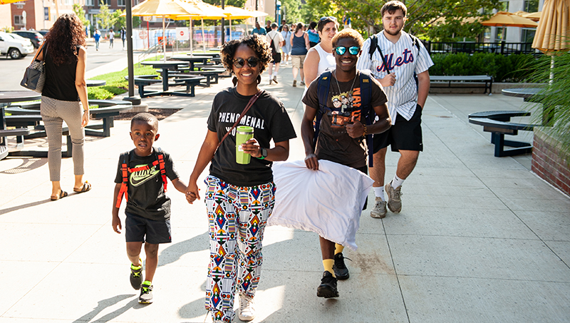 A students walk with their parents through the quad.