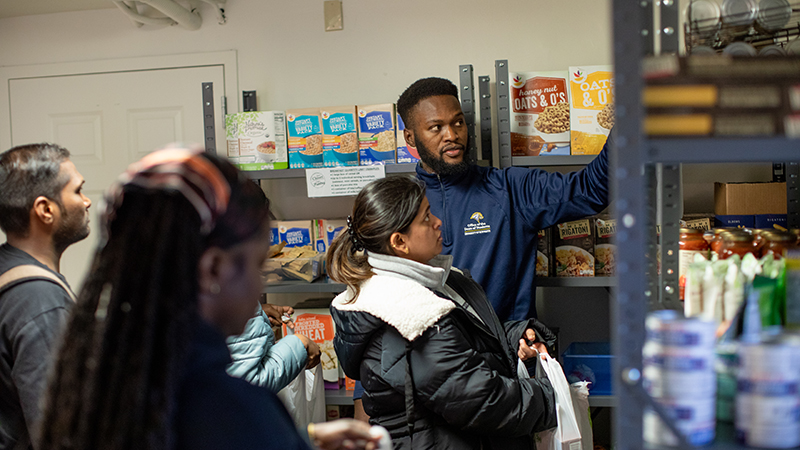 Adedayo Adekola ’24 MPH (in blue) and students in the Campus Pantry. 