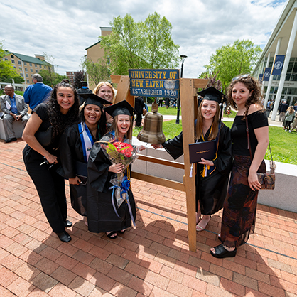 New graduates ring the Alumni Bell. 