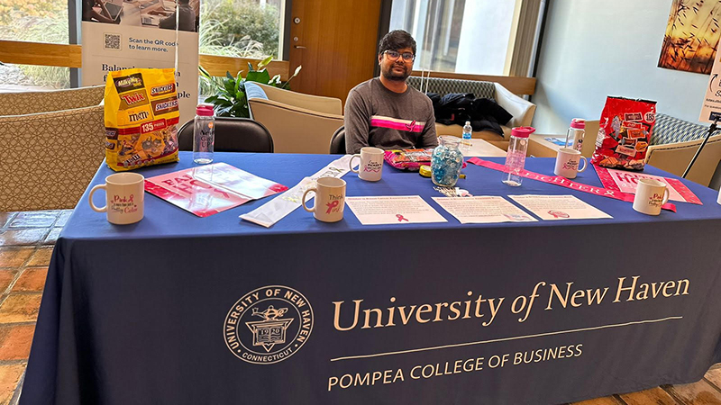 Kriston Pal ’24 M.S. raises awareness of breast cancer at a table on campus. 